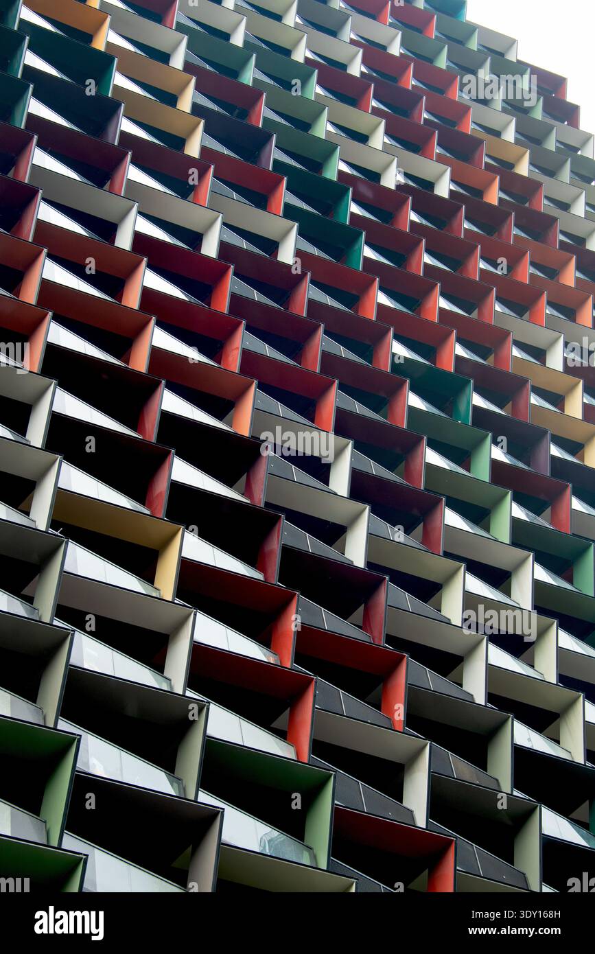 Vibrante motivo architettonico caratterizzato da sfumature geometriche multicolore all'esterno di un edificio contemporaneo. Foto Stock