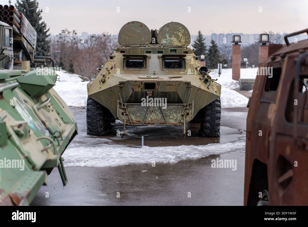 Vista di imponenti veicoli militari silenziosi su un terreno freddo e bagnato, metallo luccicante sotto il cielo coperto, Kiev, Kiev, Ucraina. Foto Stock