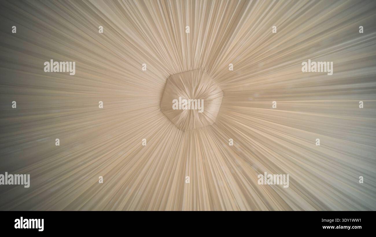 Morbidi drappi beige che cadono graziosamente, convergendo al punto focale, esaltando la location per matrimoni con un'atmosfera sofisticata e romantica Foto Stock