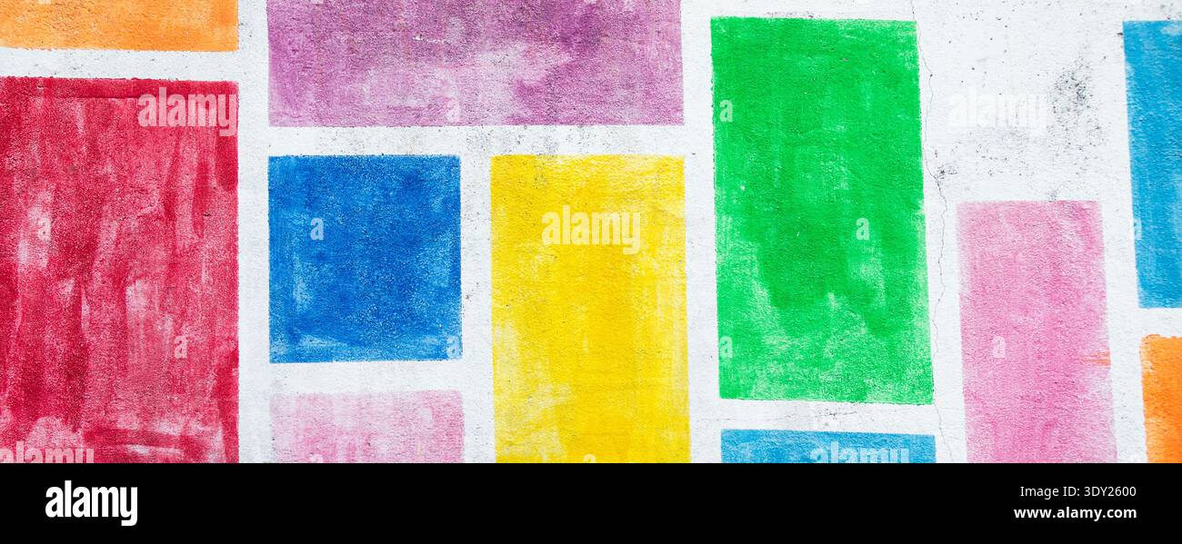 Sfondo astratto di una parete colorata dipinta con forme geometriche rettangolari in vivaci tonalità di rosso, blu, giallo, verde e viola, simbolizzazione Foto Stock
