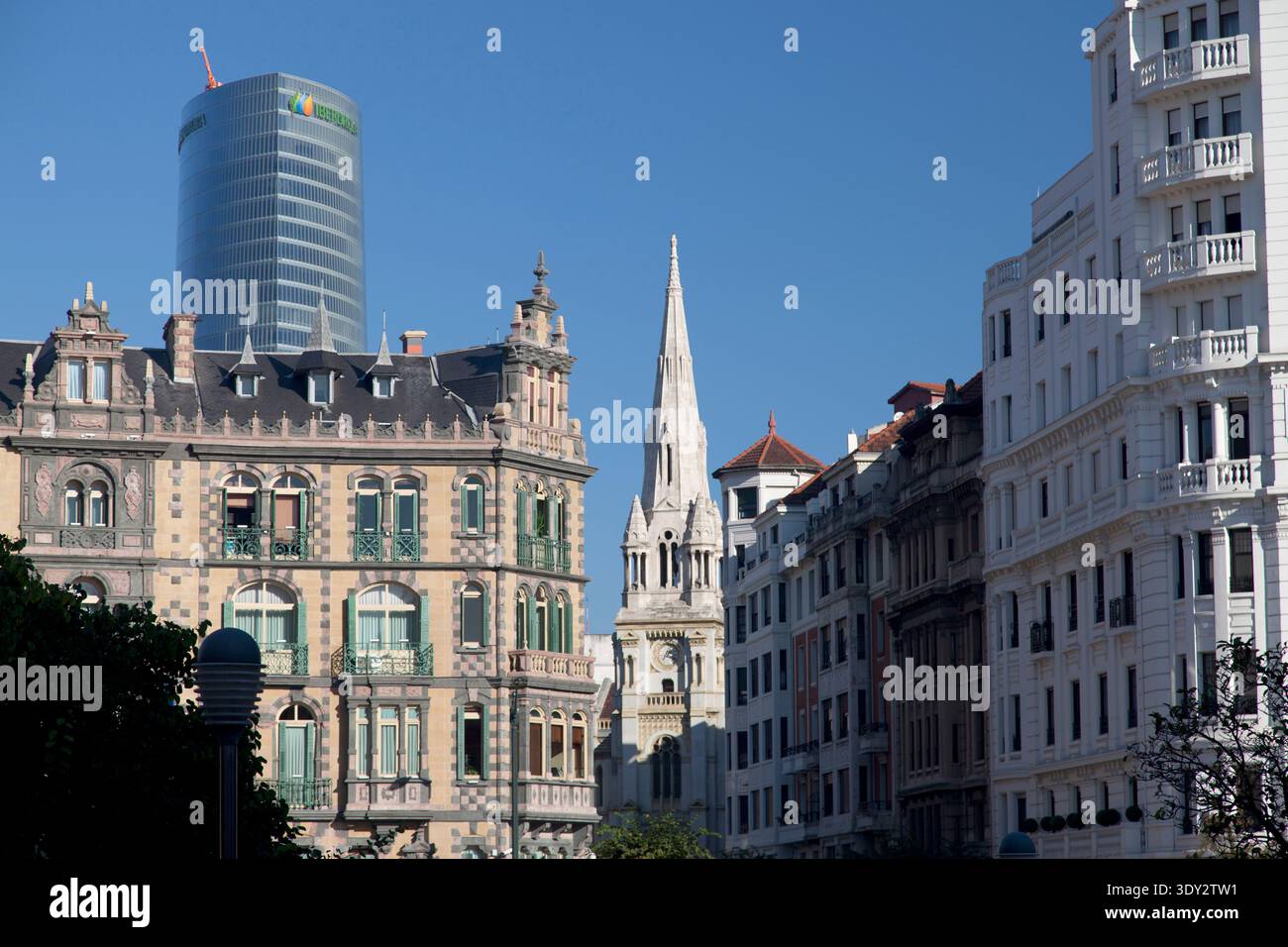 La moderna Torre Iberdrola si erge sopra la storica chiesa del Sacro cuore e le facciate ornate di Bilbao, Spagna. Foto Stock