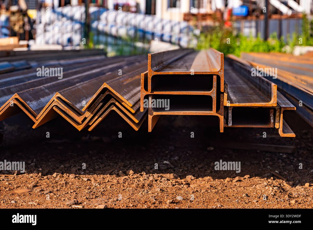 Profilati e travi in acciaio impilati in cantiere, stoccaggio di materiali edili Foto Stock