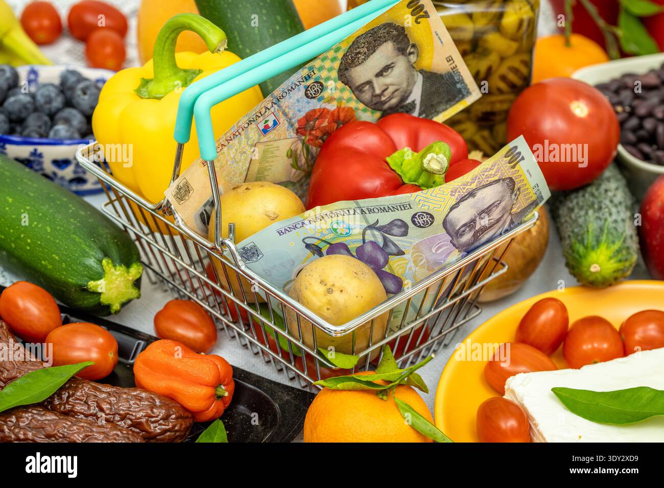 Carrello con cibo e denaro rumeno. Concetto finanziario e aziendale. Aumento dei prezzi in Romania, aumento dei prezzi alimentari. Primo piano Foto Stock