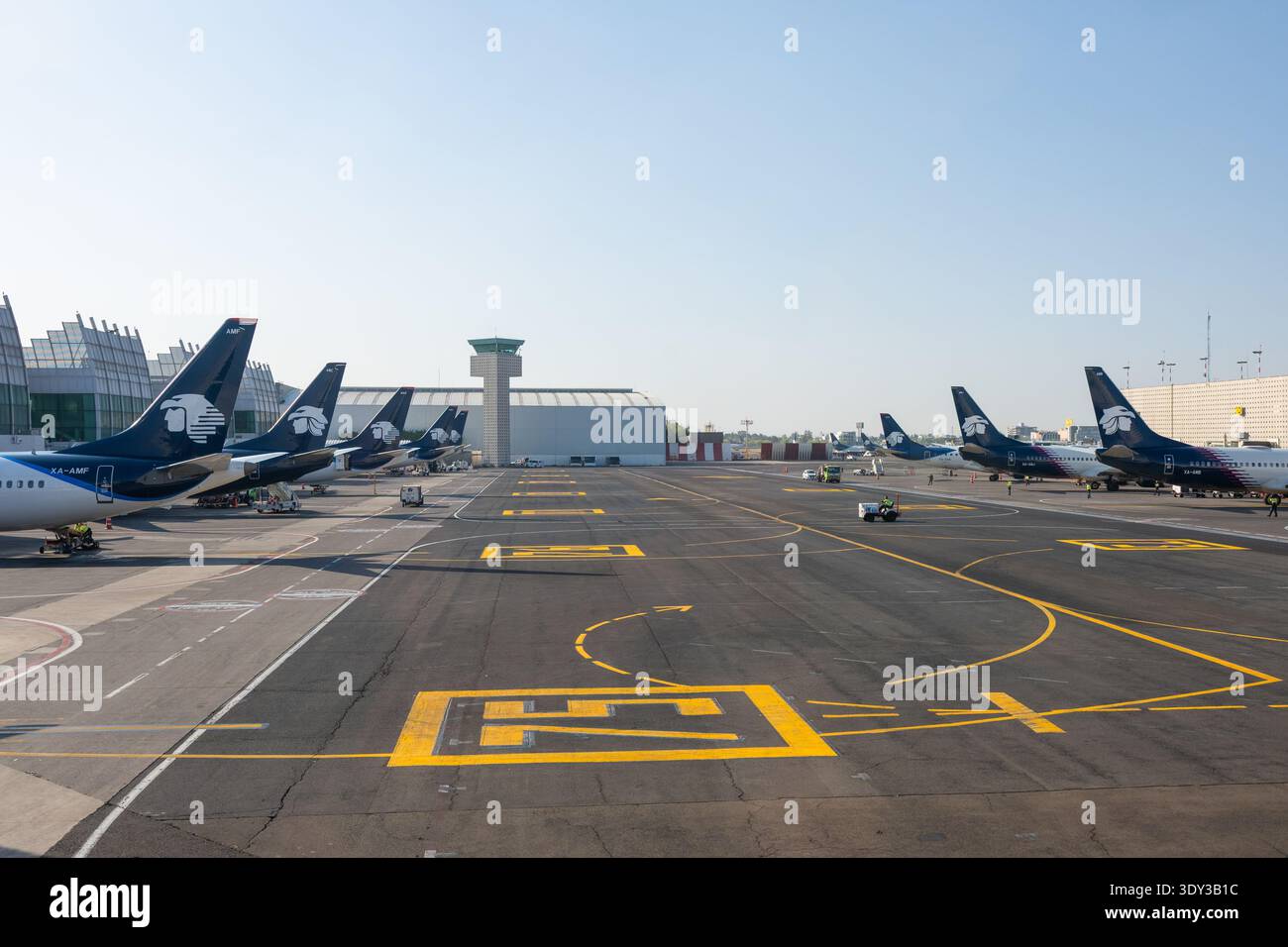 File di jet passeggeri Aeromexico parcheggiati ai cancelli del terminal con la torre di controllo sullo sfondo dell'aeroporto internazionale di città del Messico, Messico. Foto Stock