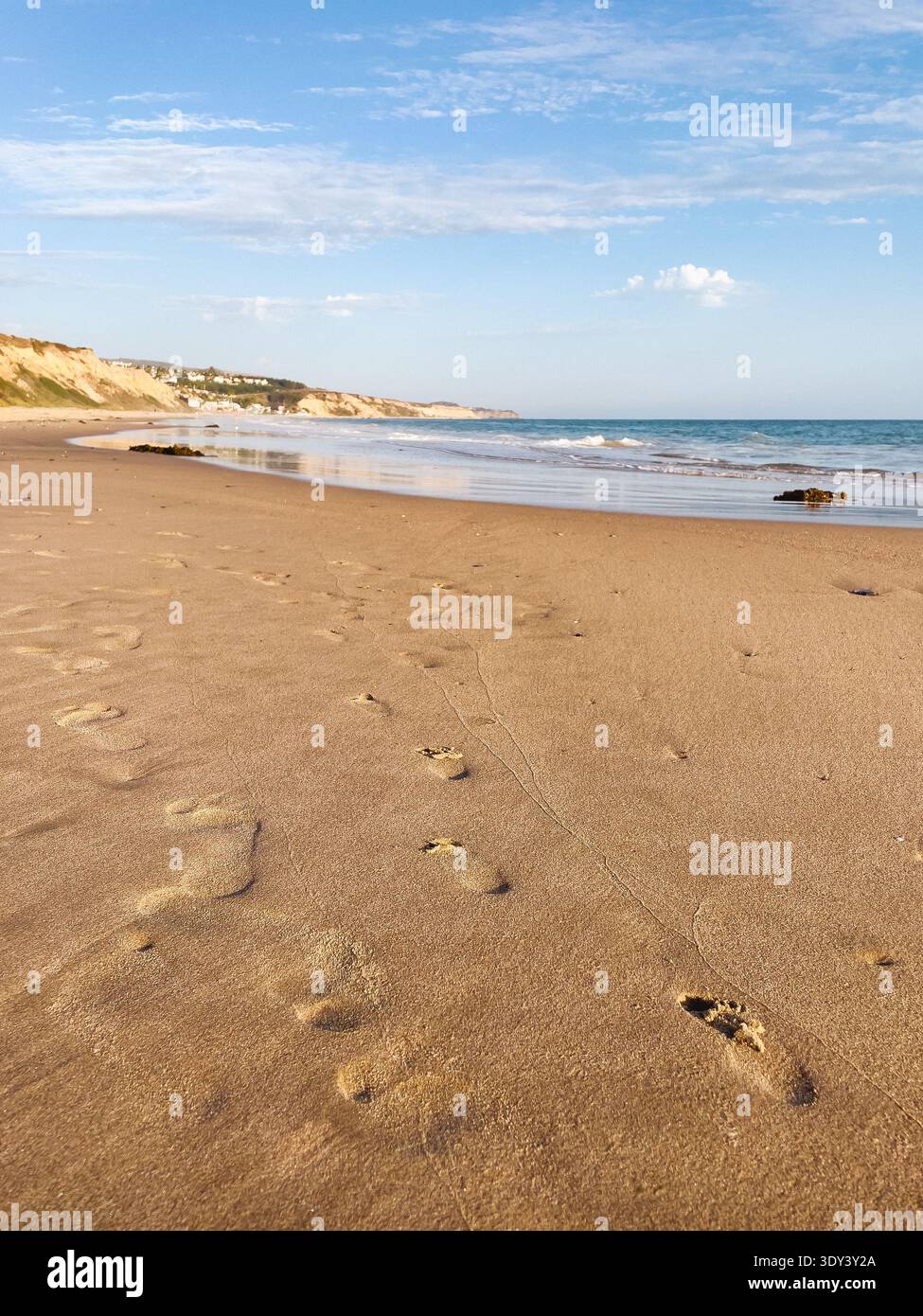 Passi sulla sabbia su una spiaggia soleggiata Foto Stock