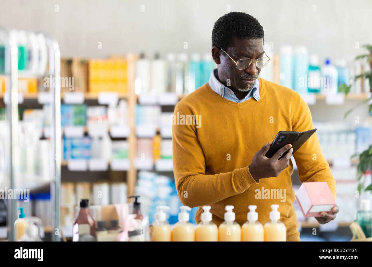 Man in Glass esegue la scansione del codice sulla confezione di pillole per controllare la data di scadenza Foto Stock