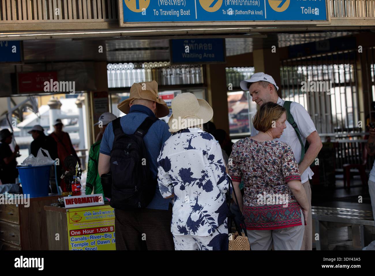 BANGKOK, THAILANDIA - 7 febbraio 2026: Turisti anziani in attesa di acquistare i biglietti del battello, divertimento all'aperto, vista sul retro, a Tha Chang. Foto Stock