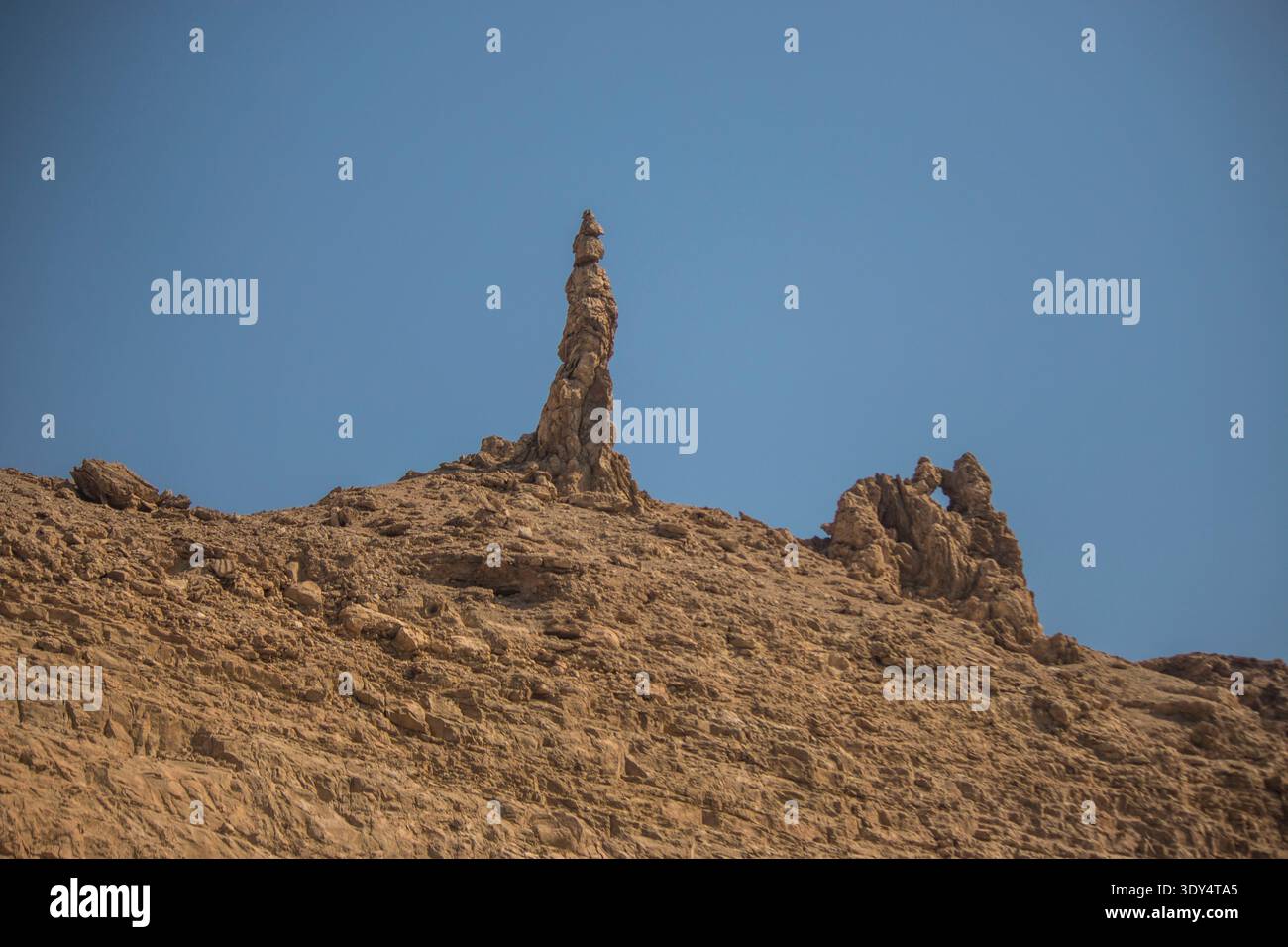Vista dal basso angolo del pilastro della moglie di Lot, la formazione di rocce salate nelle aride colline desertiche della Giordania, un punto di riferimento biblico venerato attraverso le sacre tradizioni. Foto Stock