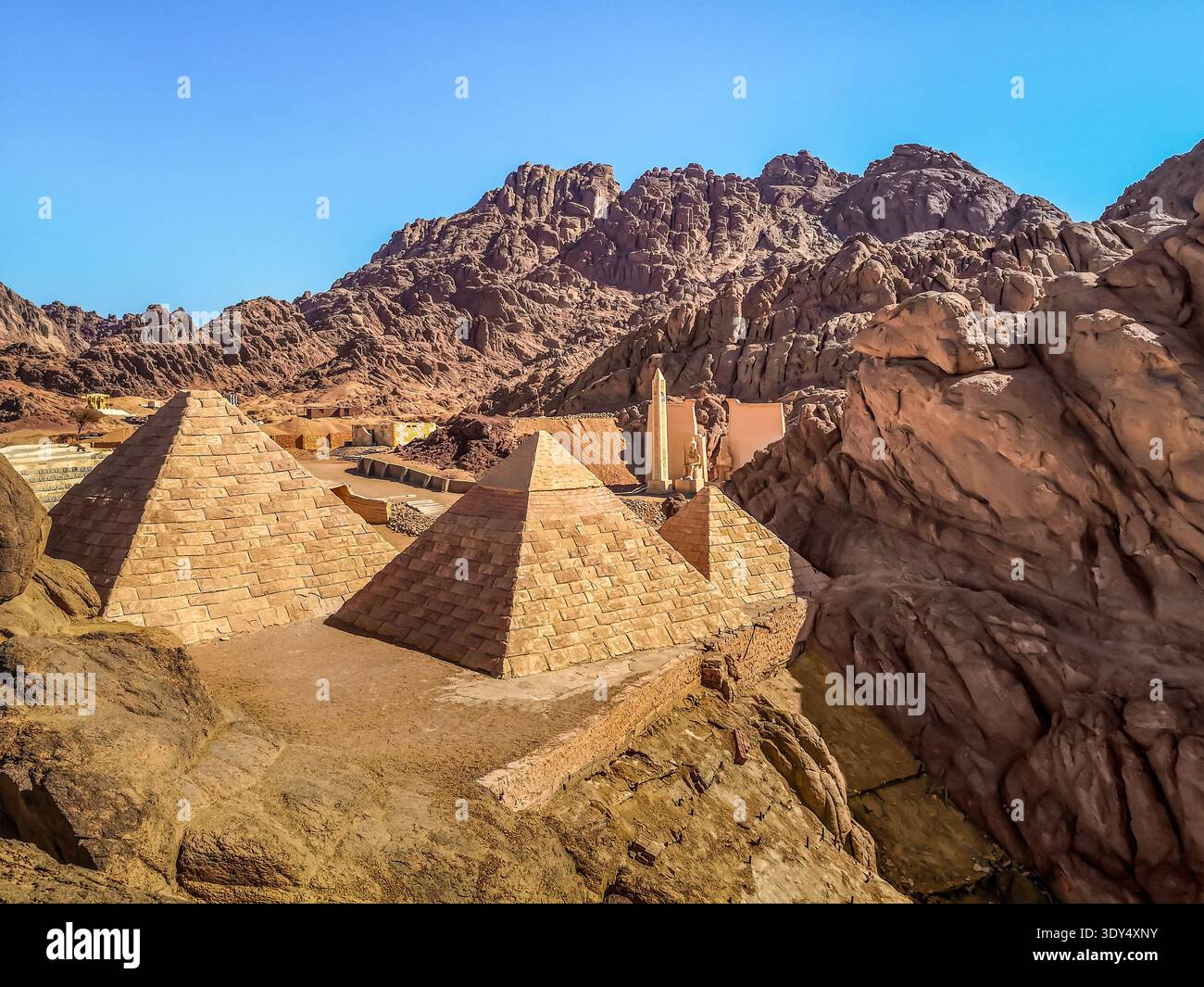 Copie delle piramidi egiziane tra le montagne di pietra del deserto vicino a Sharm El Sheikh, Egitto. Edifici turistici nel deserto del Sinai Foto Stock