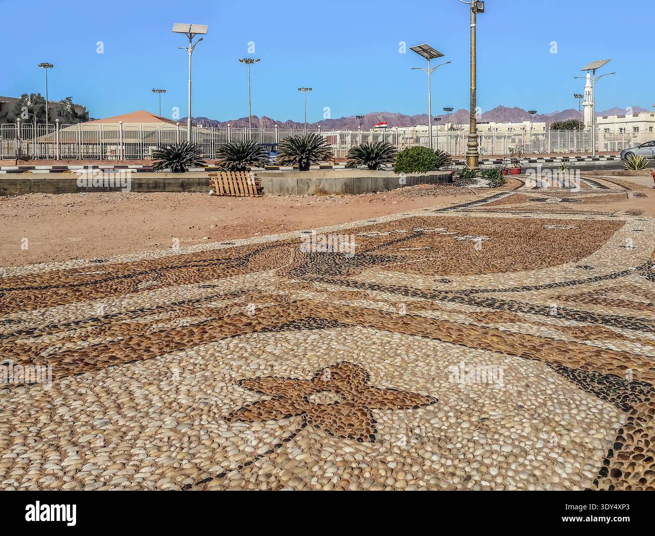 Motivo decorativo sulla piazza della città pavimentata con piccoli ciottoli da spiaggia a Sharm El Sheikh, Egitto. Pavimentazione creativa nella città turistica egiziana Foto Stock