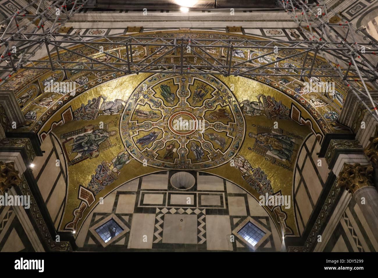 Soffitto decorato a mosaico dorato con simbolismo religioso e ponteggi di restauro all'interno dello storico Battistero di Firenze, che fonde arte sacra. Foto Stock