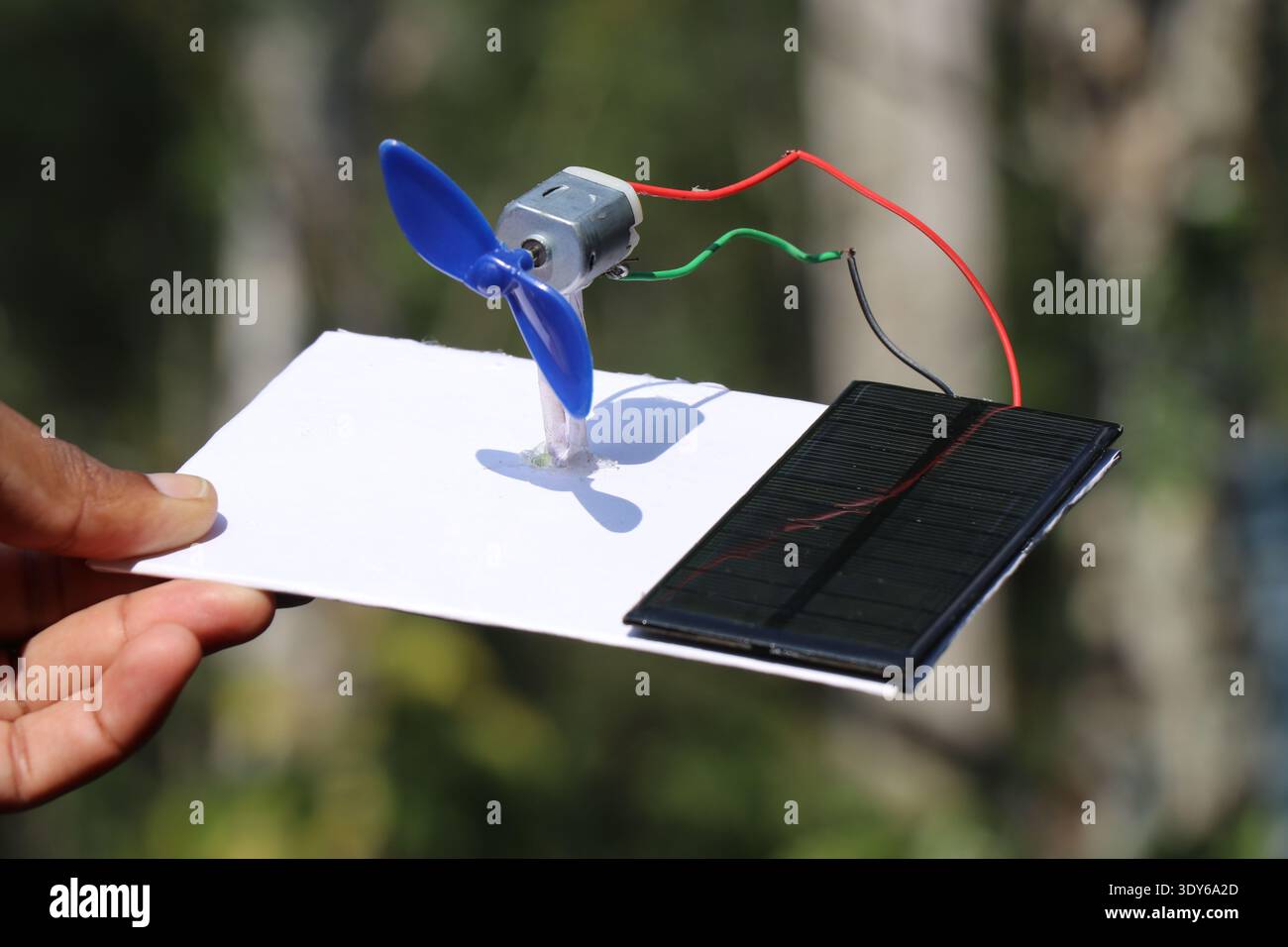 Pannello solare che alimenta un piccolo modello di mulino a vento che mostra il concetto di energia verde. Fonti di energia ecocompatibili Foto Stock
