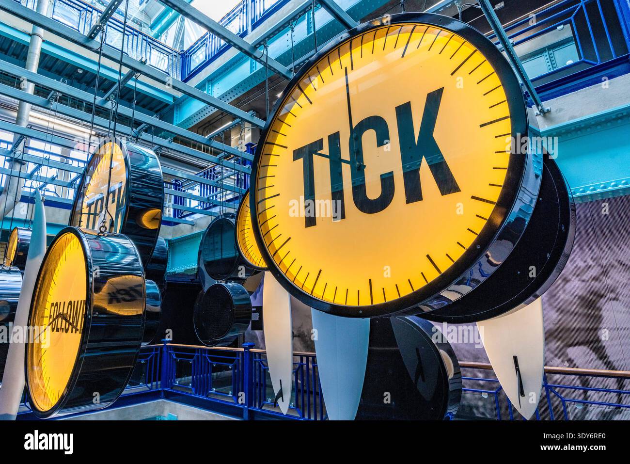 I grandi orologi gialli mostrano il segno di spunta all'interno della Guinness Storehouse di Dublino, Irlanda, durante l'orario di visita Foto Stock