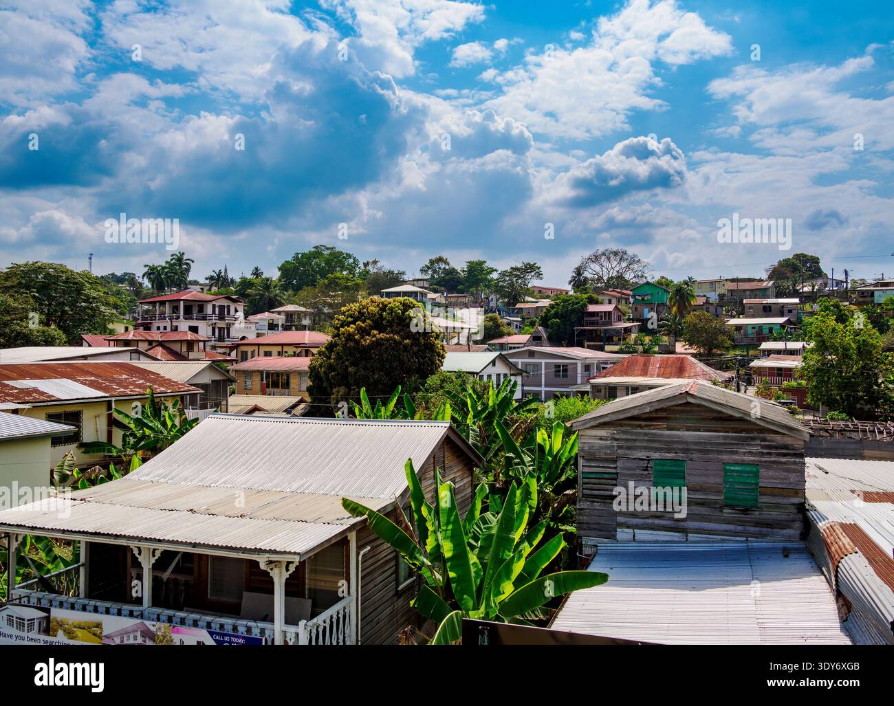 Vista sopraelevata del paesaggio urbano di San Ignacio che mostra tetti, alberi ed edifici sotto un cielo parzialmente nuvoloso in Belize Foto Stock