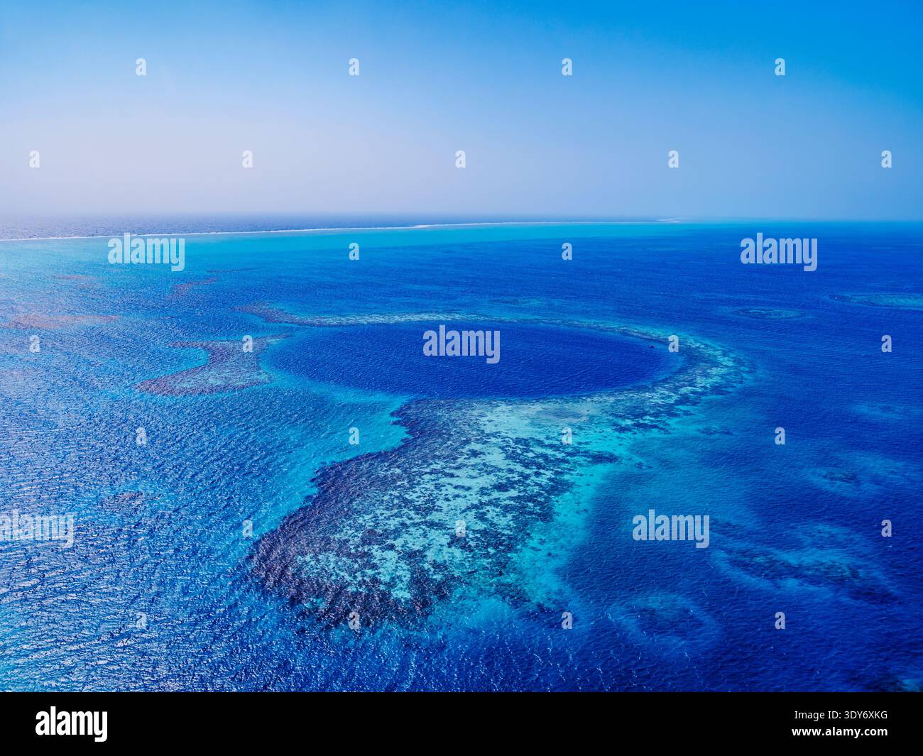 La vista del Great Blue Hole presso il Lighthouse Reef in Belize dall'alto offre una prospettiva unica sulle formazioni sottomarine di natureâs Foto Stock
