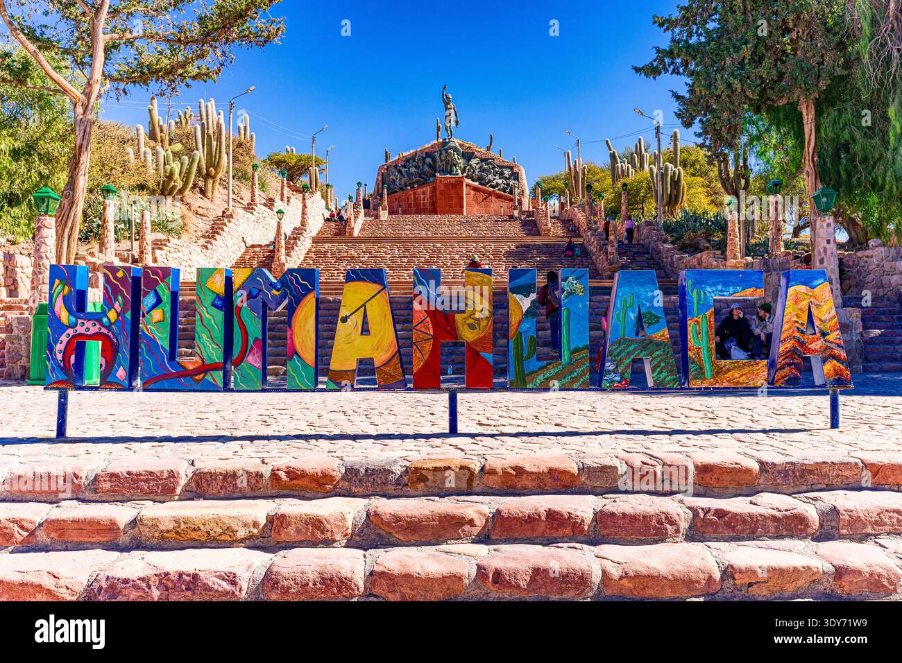 Il cartello mostra il nome di Humahuaca con sullo sfondo il Monumento agli Eroi dell'indipendenza, evidenziando il punto di riferimento culturale in Argentina Foto Stock