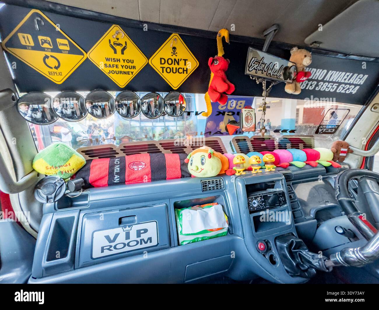 Gli interni dell'autobus decorati mostrano lo stile dell'autista a Maumere, Flores, Indonesia, con accessori colorati e decorazioni uniche Foto Stock