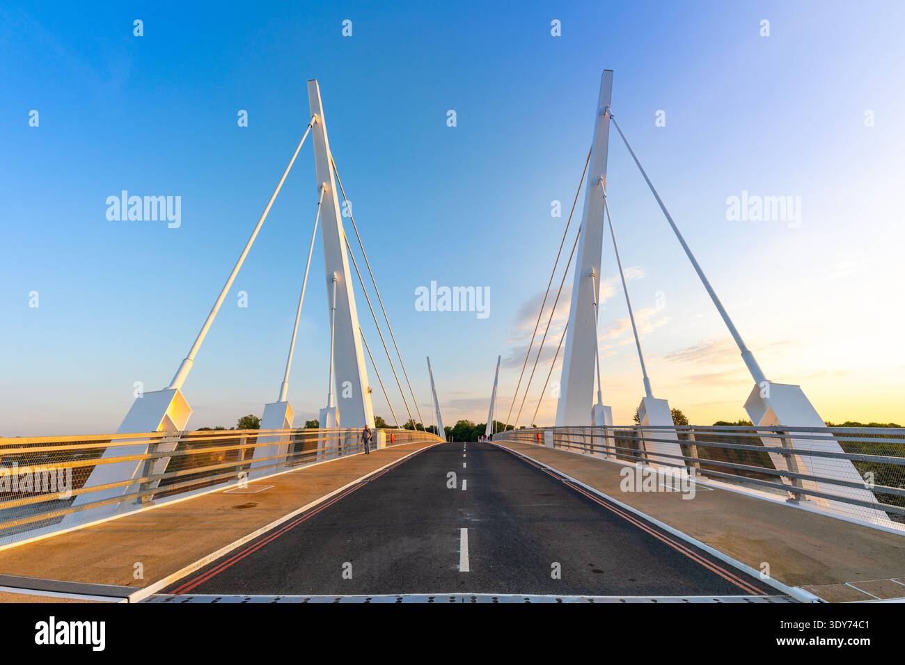 Il ponte strallato a doppio battente collega due lati di Glasgow al tramonto con cieli limpidi e strade per i veicoli Foto Stock