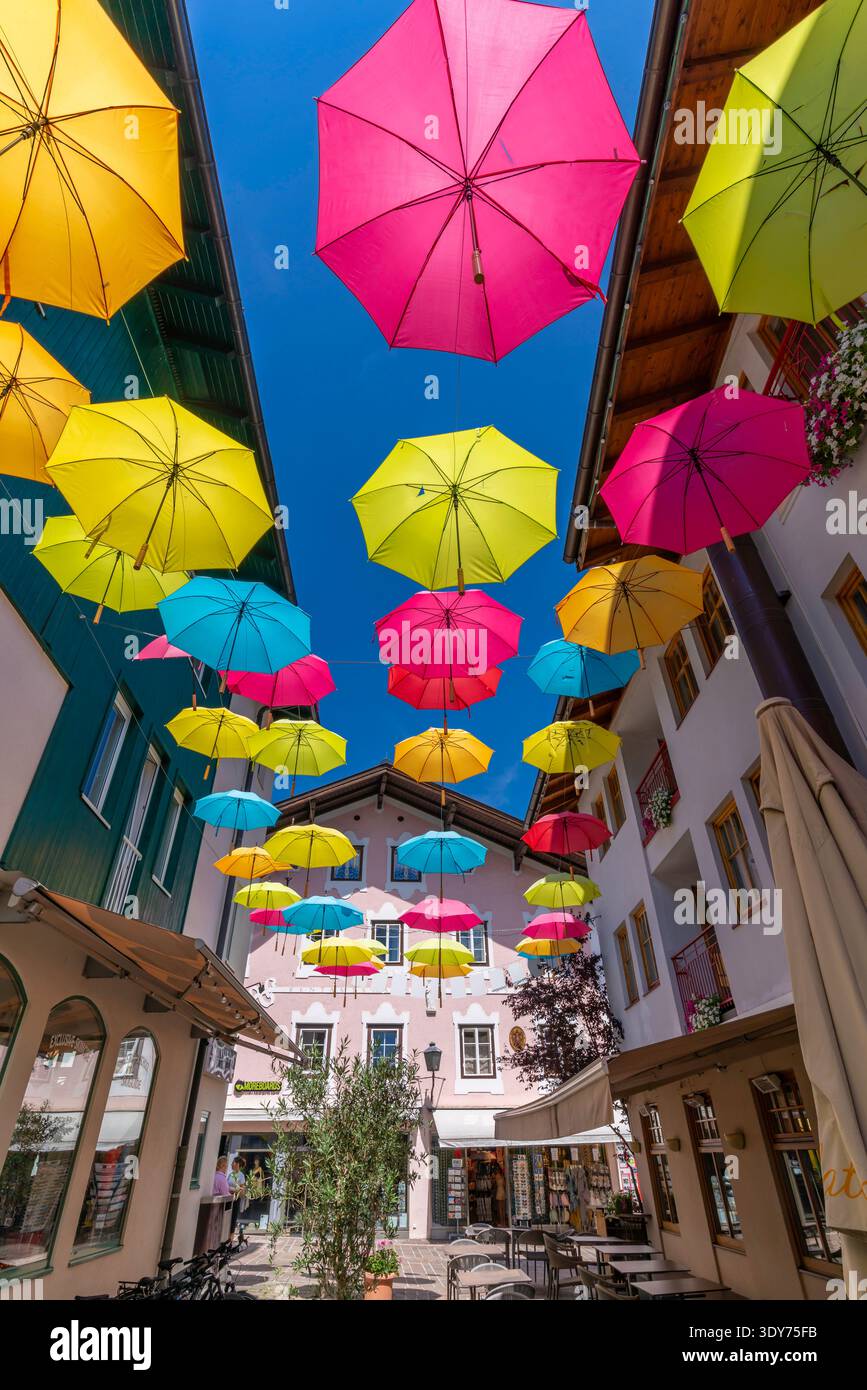 Ombrelli colorati sono appesi sopra un cortile di Zell am SEE in una giornata di sole a Salisburgo, Austria Foto Stock