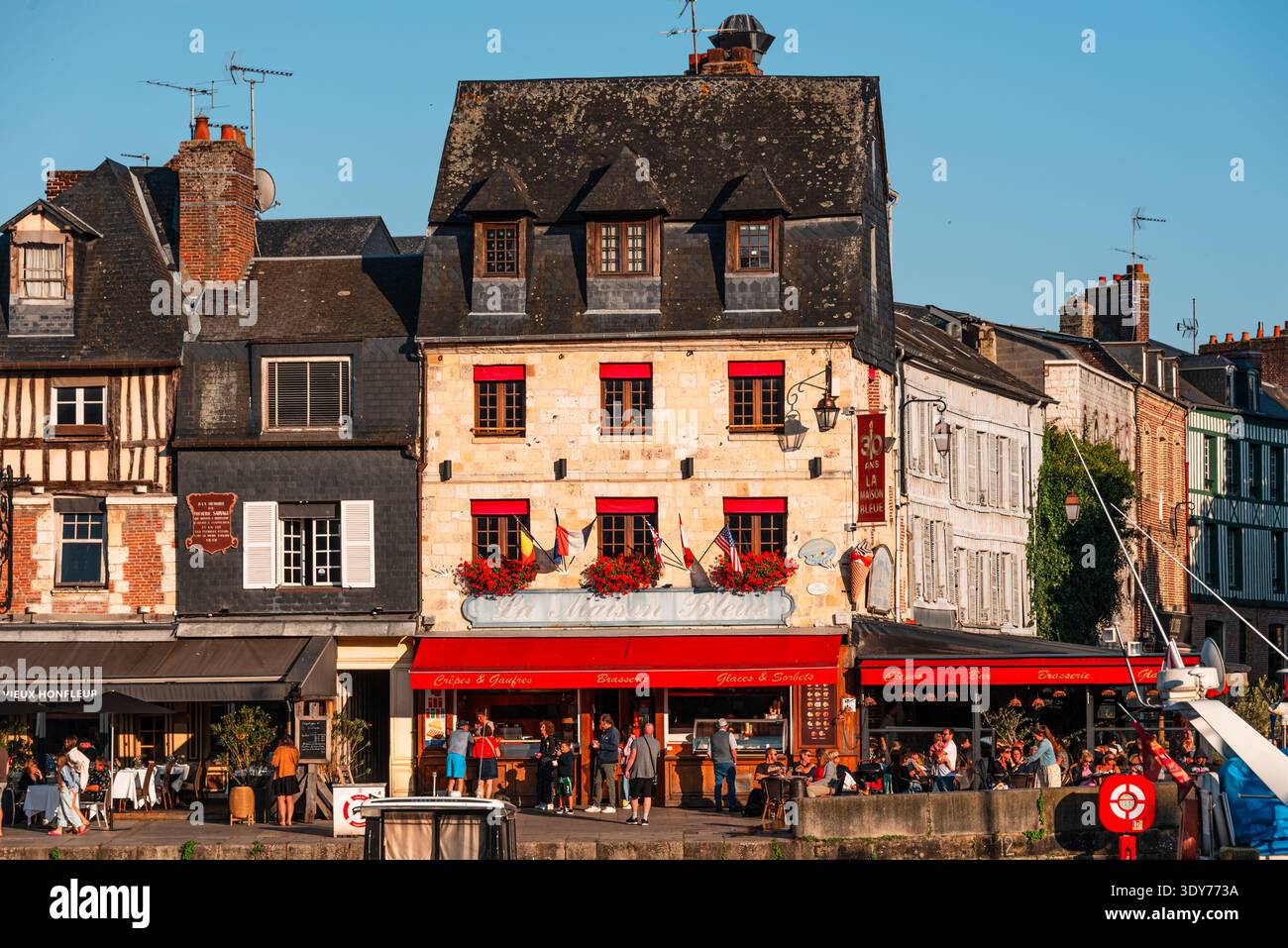 Case a graticcio con persiane colorate e fiori nella città storica di Honfleur, Normandia, Francia Foto Stock