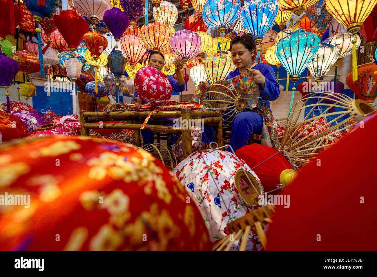 Le donne realizzano lanterne colorate a Hoi An durante la tradizionale stagione dei festival in Vietnam Foto Stock