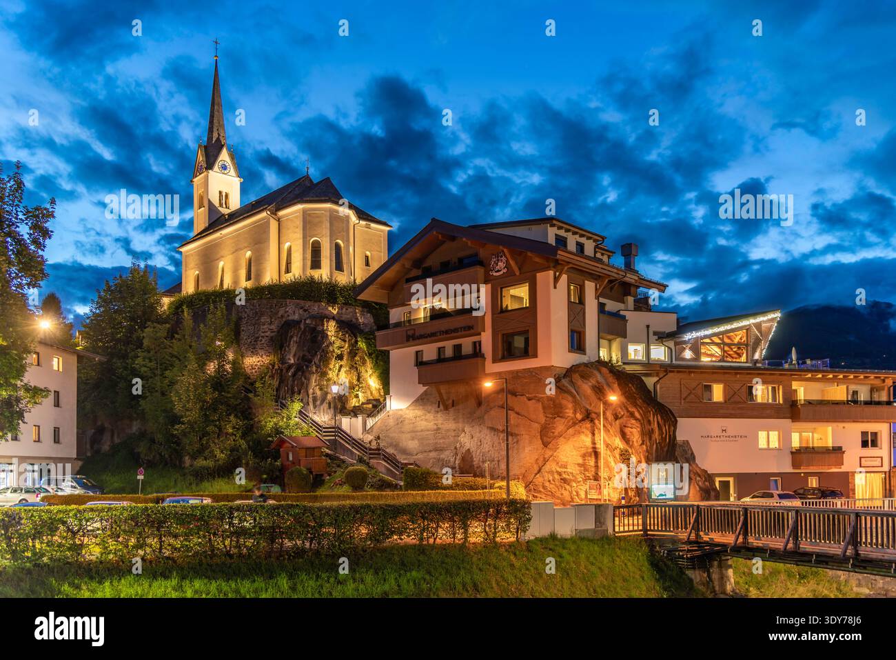 Vista serale estiva della chiesa e degli edifici di Kaprun con cielo limpido e luce crepuscolare Foto Stock