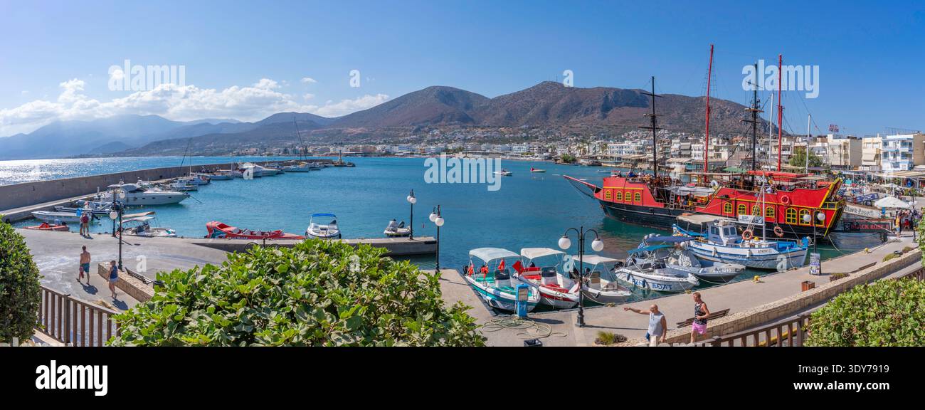 Barche e persone che amano le attività a Limenas, porto Chersonisou, Creta, Grecia con il sole Foto Stock