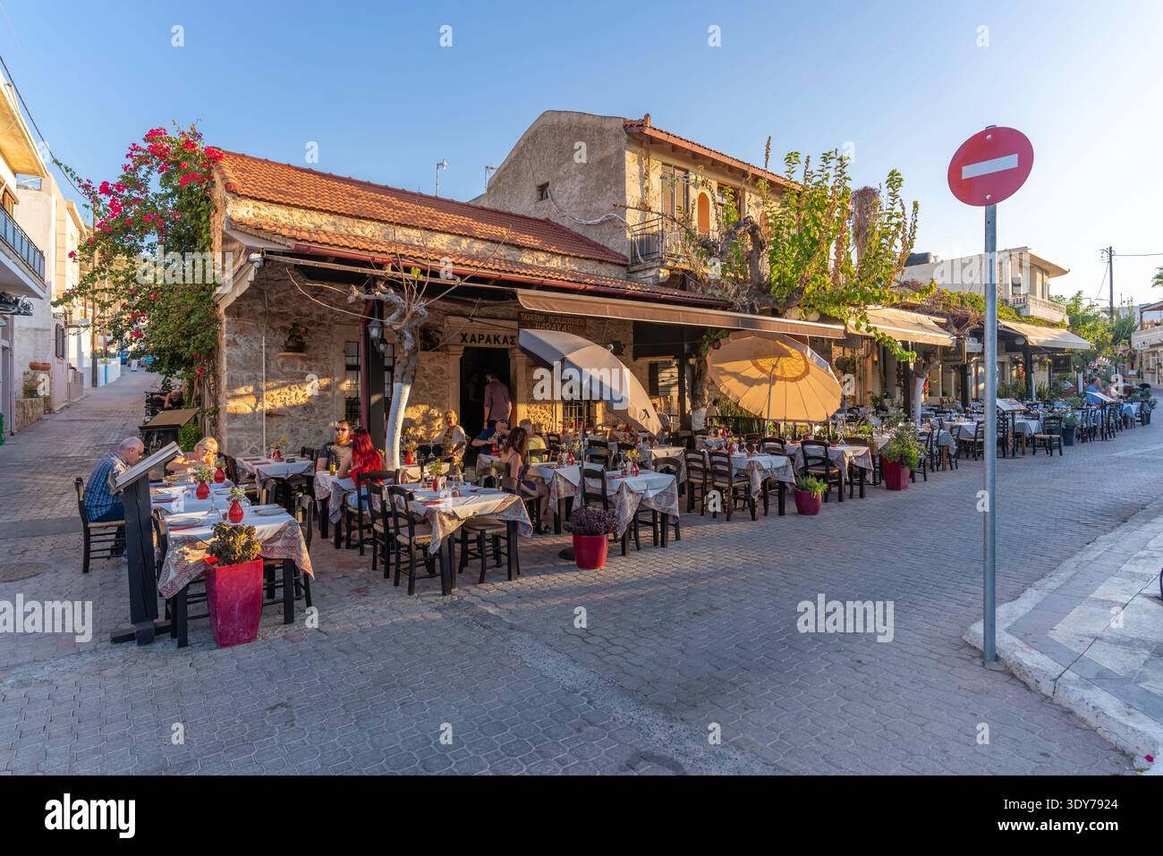 Cenare in una taverna durante una calda serata a Creta con un'atmosfera amichevole e vivaci cene in un ambiente all'aperto Foto Stock