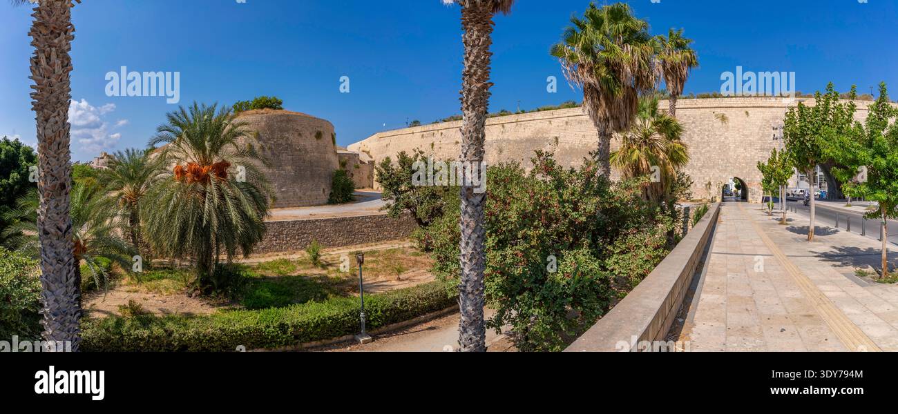 Giorno di sole luminoso che mostra le mura veneziane di Heraklion, un sito storico a Creta, in Grecia, con palme in primo piano Foto Stock