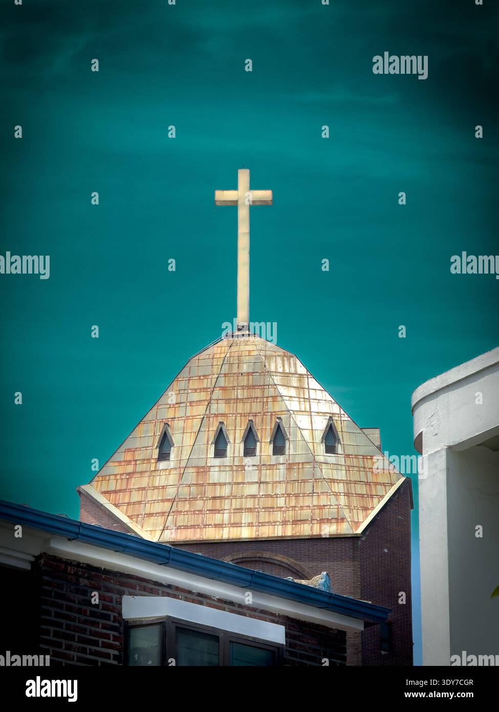 Torre della chiesa con una croce in cima contro un cielo azzurro, architettura religiosa e simbolo cristiano. - Immagine stock catturata con smartphone