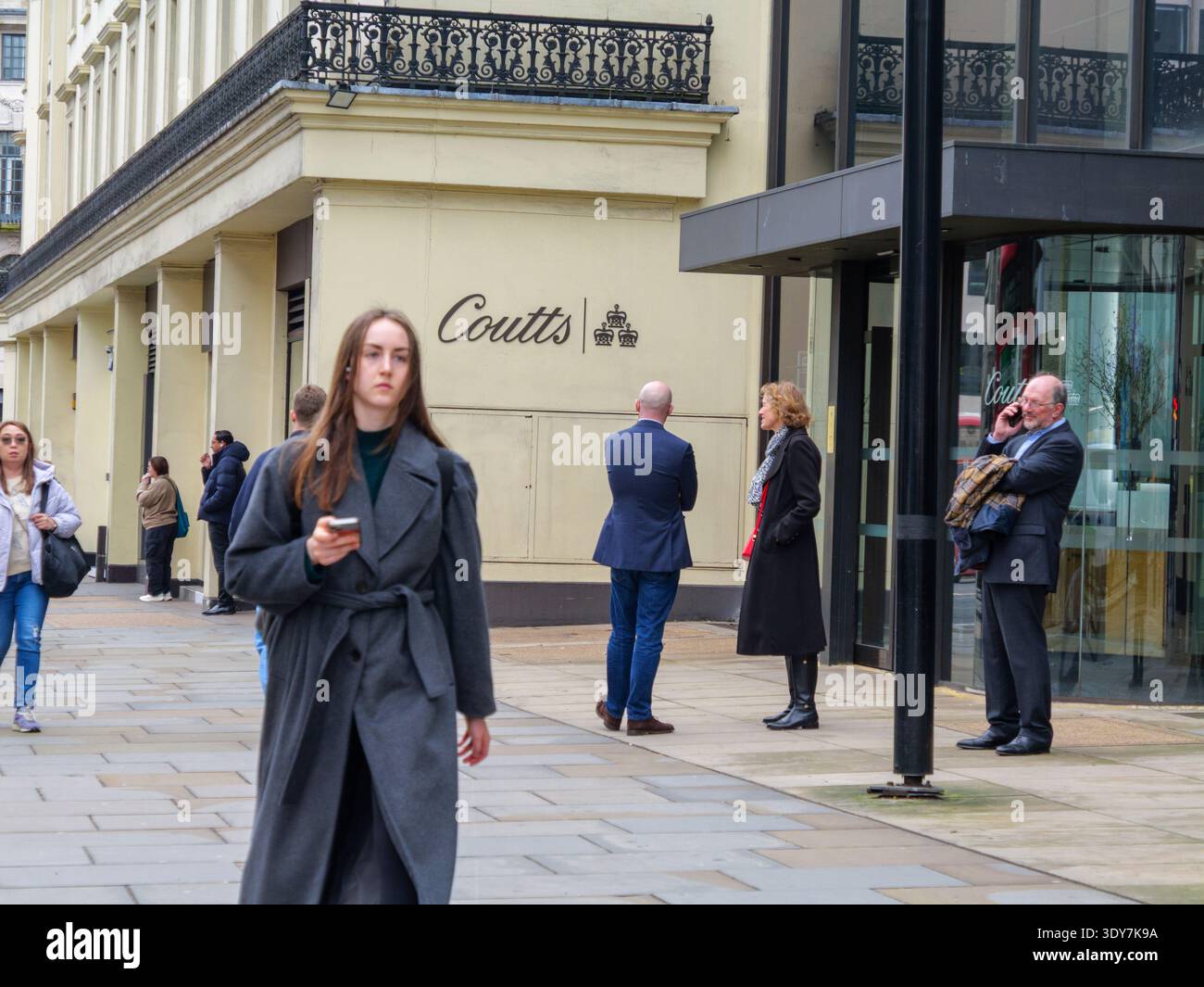 Professionisti e lavoratori cittadini ben vestiti e adatti si riuniscono fuori dalla prestigiosa sede di Coutts & Co. Al 440 The Strand, Londra, nel febbraio 2026. Fondata nel 1692, Coutts è una delle banche private più esclusive al mondo, che richiede ai clienti di mantenere almeno 1 milione di sterline in attività investibili Foto Stock