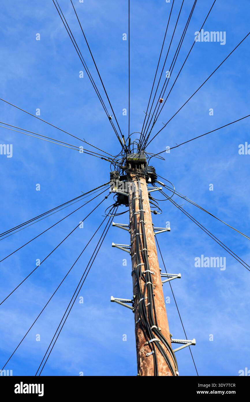 Palo in legno Telegraph con molti cavi che irradiano dalla parte superiore. Telefono, wi-fi. Contro il cielo blu. Foto Stock