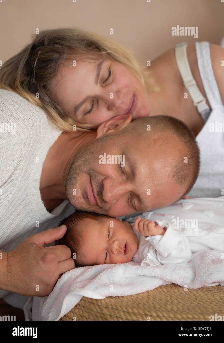 Genitori che dormono con neonato a letto Foto Stock