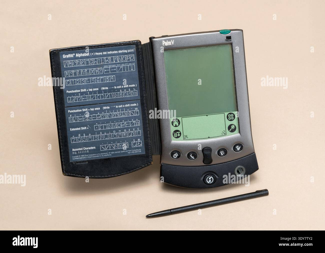 Milano, Lombardia, Italia - 23 novembre 2024: Palmare Palm V con stilo e scheda alfabetica graffiti che illustra il mobile computing vintage del 1999. Mostrato a Foto Stock