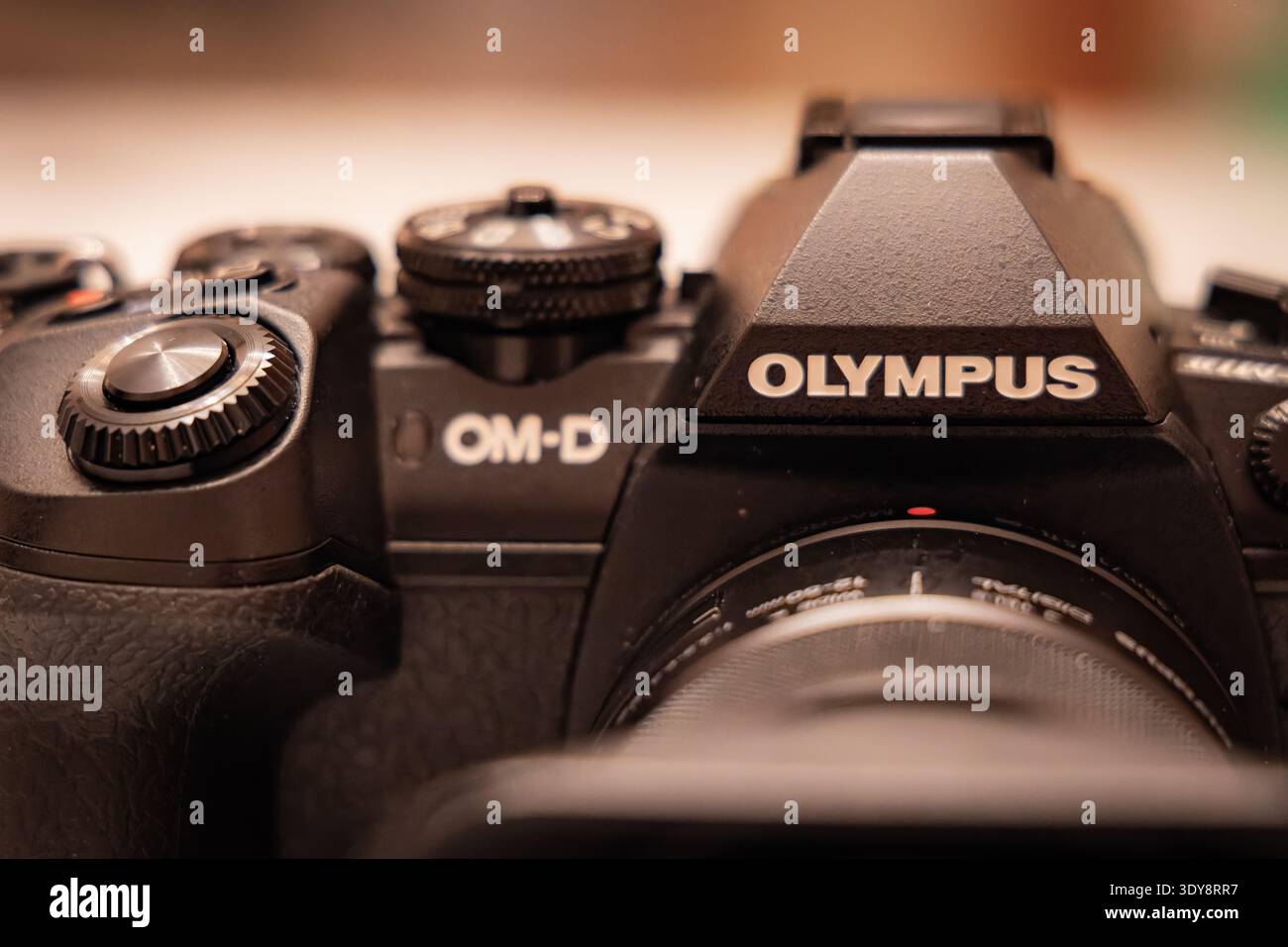 Vista macro ravvicinata del corpo della telecamera mirrorless Olympus OM D con il logo Olympus e i comandi con profondità di campo ridotta Foto Stock