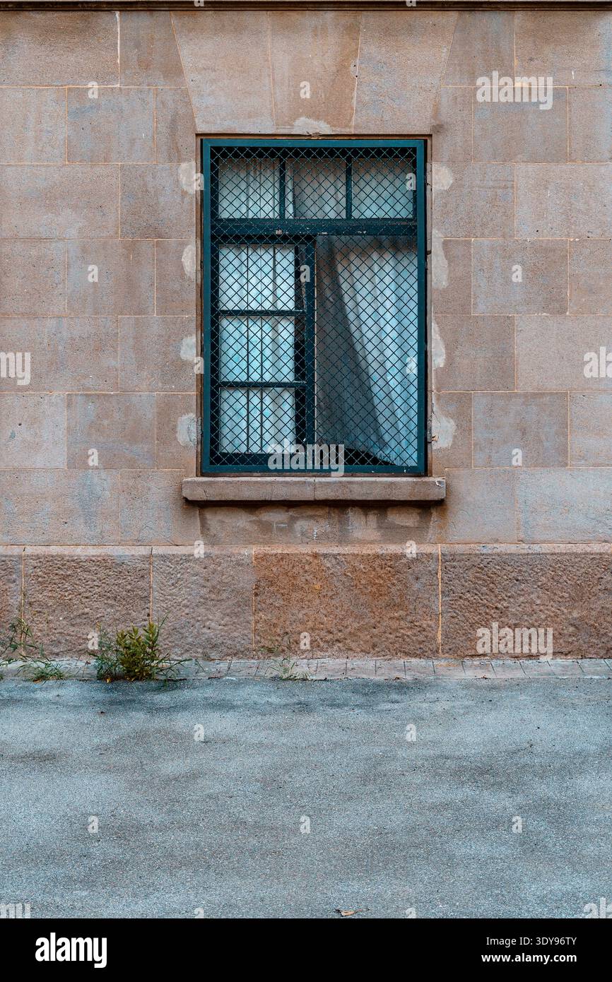 Facciata di una vecchia casa, finestra di ferro con tende bianche che sbattono nel vento. Foto Stock