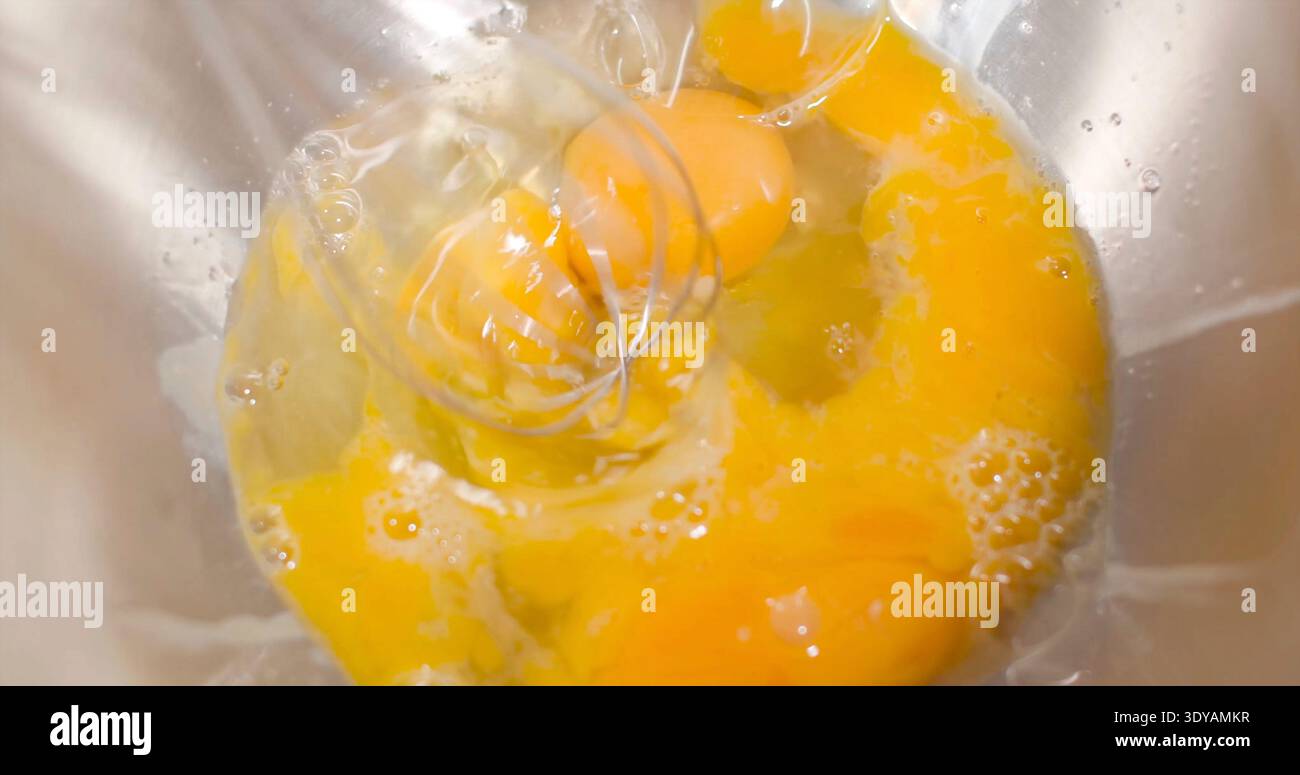 Mescolare le uova in un recipiente per cucinare in cucina durante le ore diurne Foto Stock