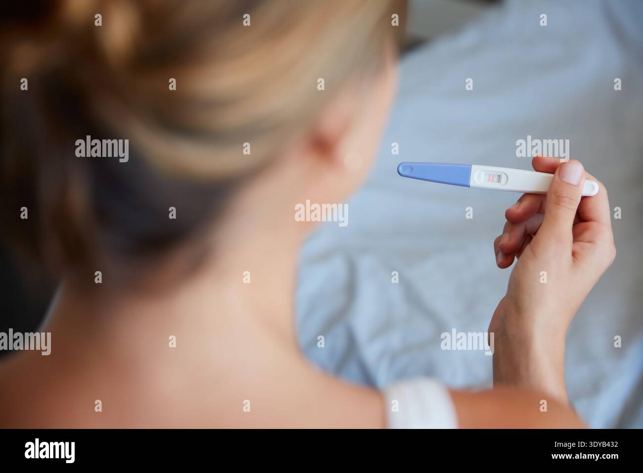 Casa, donna e lettura con test di gravidanza per risultati, conferma e buone notizie per il concepimento. Informazioni, maternità o persona con stick check Foto Stock