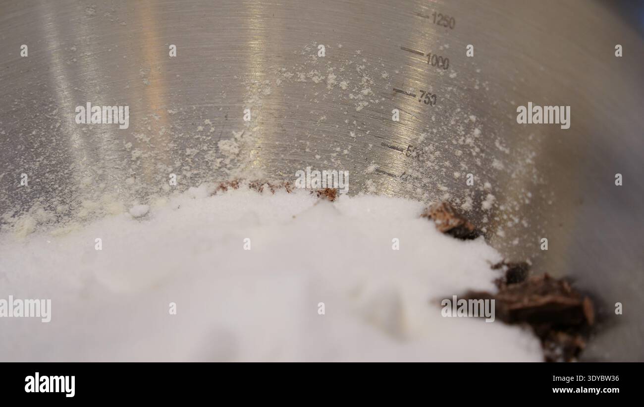Pezzi di cioccolato e farina nel recipiente per la preparazione dei biscotti Foto Stock