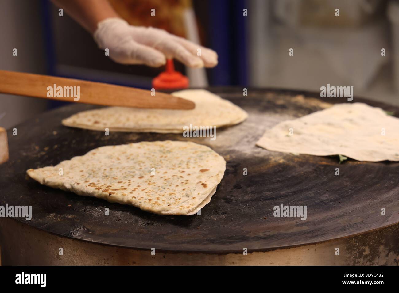 Uomo che prepara pane arabo nel Global Village Foto Stock