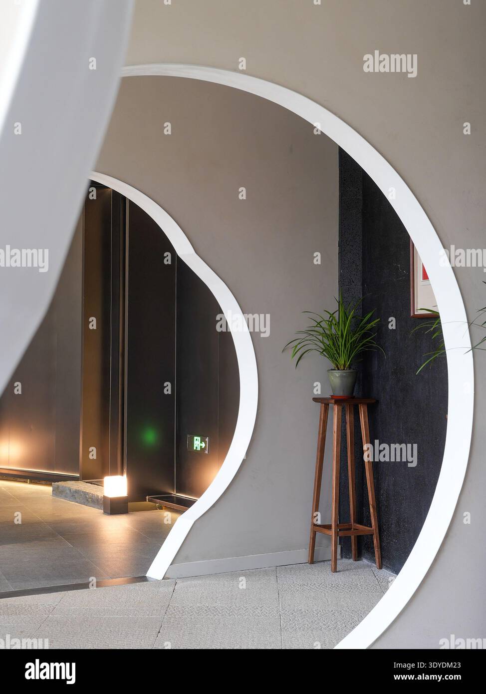 Una moderna arcata curva che incornicia uno spazio interno con un design minimalista e linee pulite. L'immagine trasmette raffinatezza, eleganza strutturale, minim Foto Stock