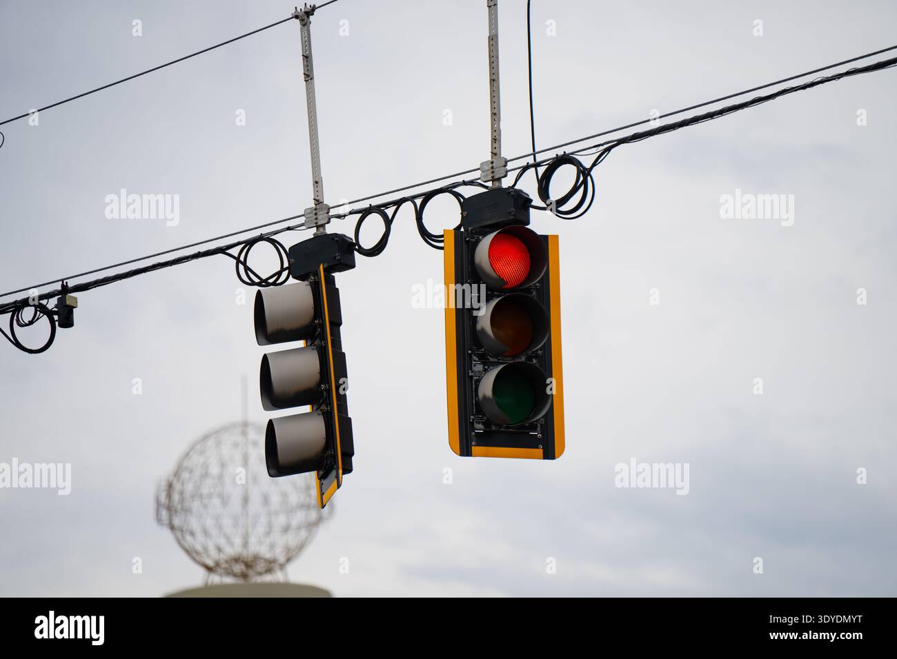 Gruppo segnale di intersezione sospeso con luce rossa illuminata e cavi sospesi, che mostrano il controllo del traffico cittadino, le regole di guida e la carreggiata americana Foto Stock