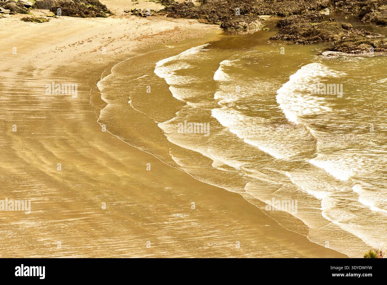 Vista aerea di una spiaggia con un motivo di onde da una marea uscente che si lava su una spiaggia. Niente persone. Sfondi. Foto Stock