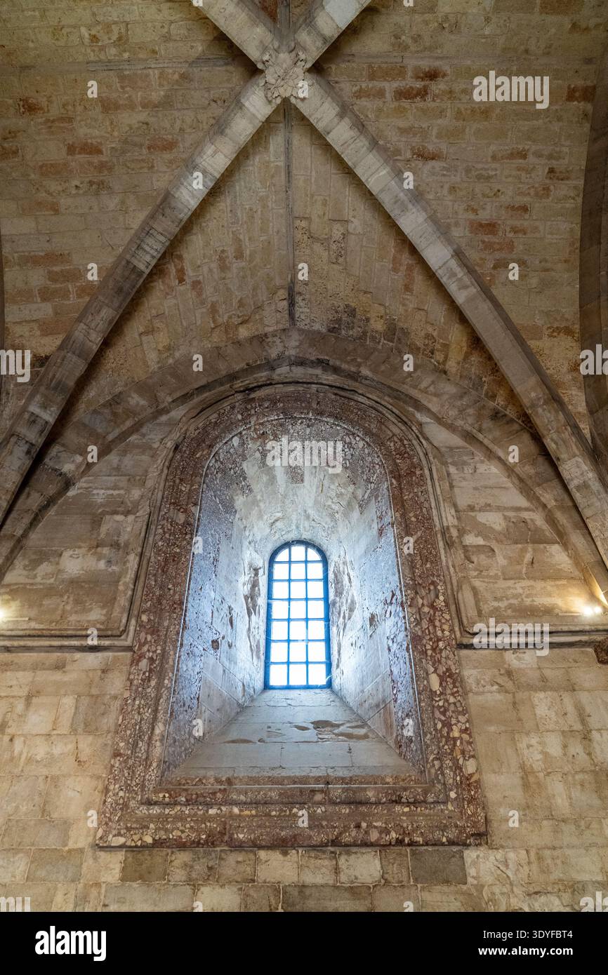 Dettagli architettonici interni di Castel del Monte. L'immagine mostra una volta a costole in pietra e una profonda finestra ad arco decorata con marmo corallino breccia. Mag Foto Stock