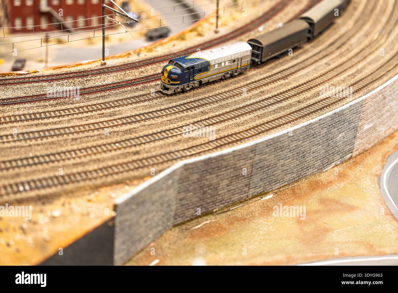 Scenografia della ferrovia in miniatura Un treno in miniatura allestito su una pista curva Foto Stock