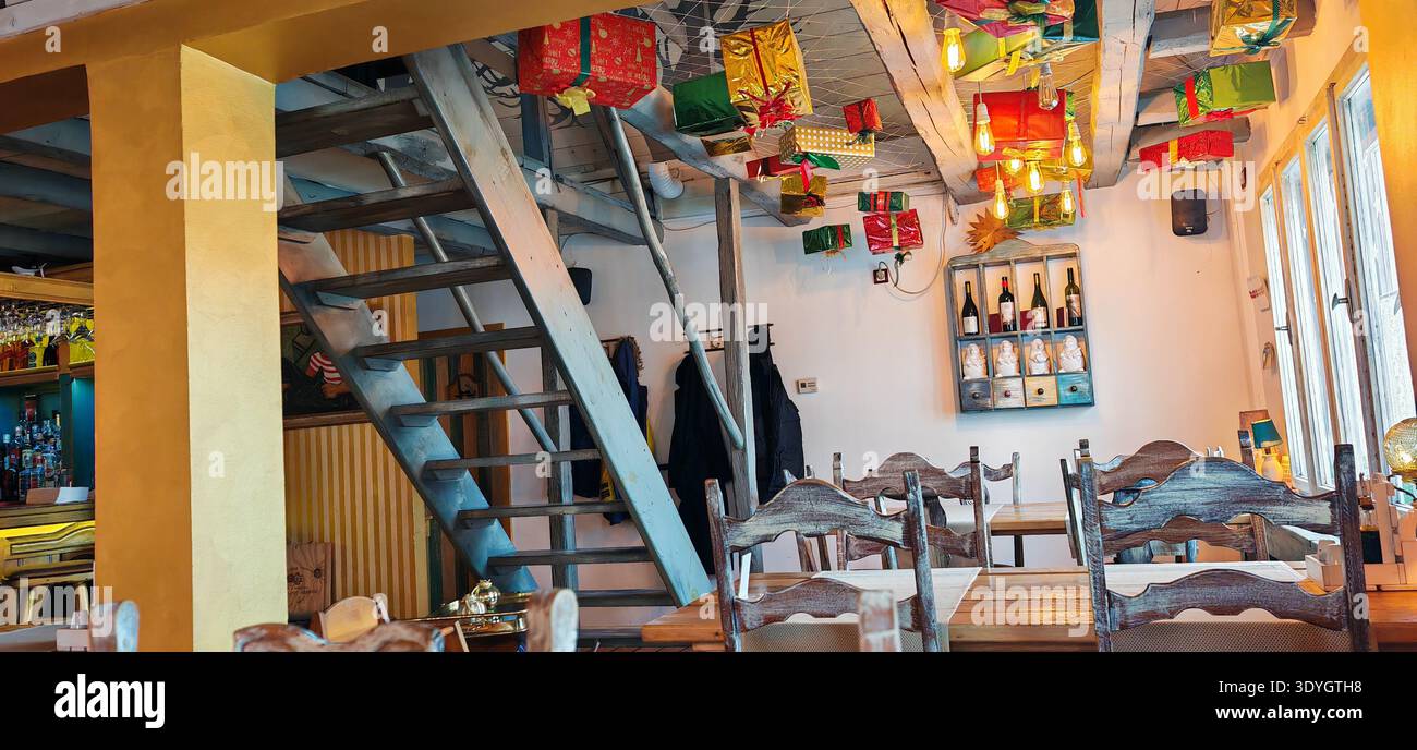Accogliente ristorante rustico interno sotto la scala di legno Foto Stock