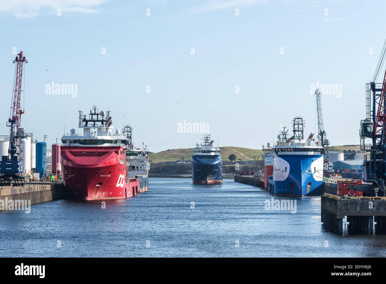 Aberdeen, Scozia, Regno Unito - 6 marzo 2025: Grandi navi di rifornimento offshore attraccate lungo il fiume Dee al porto di Aberdeen, con gru e infrastrutture portuali Foto Stock
