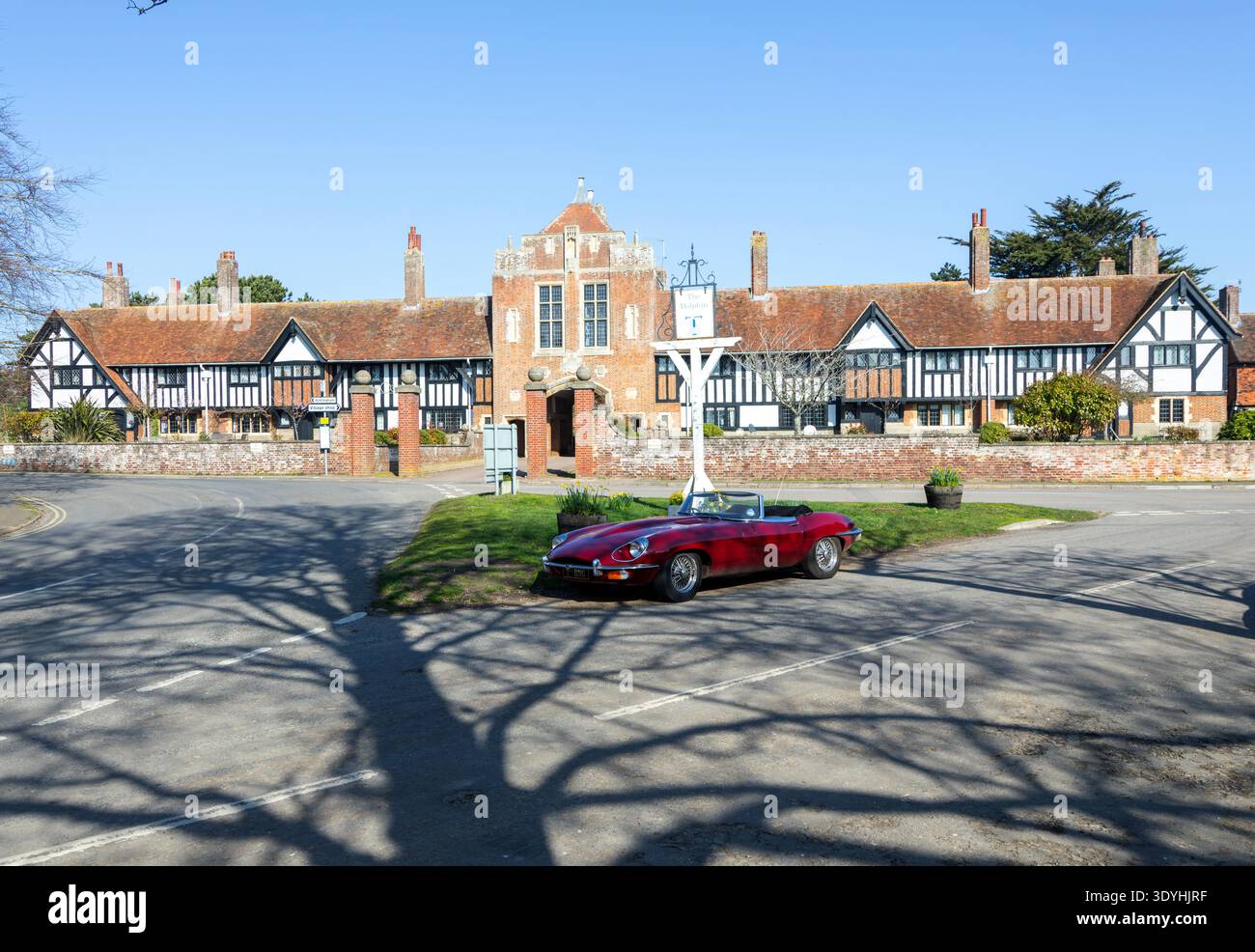 Margaret Ogilvie Almshouses, Thorpeness, Suffolk, Inghilterra, Regno Unito con Jaguar e-Type roadster open-top car Foto Stock