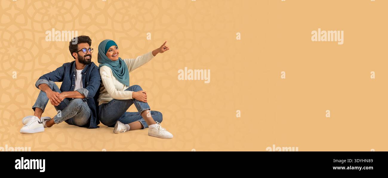 Due amici si siedono insieme, un punto e l'altro sorride nel momento divertente che condividono Foto Stock