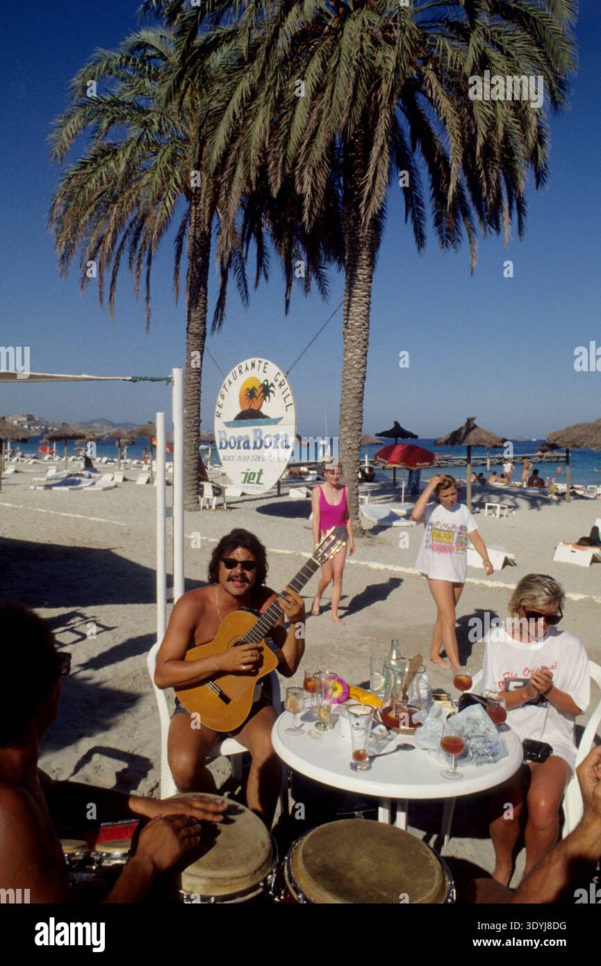 spagna ibiza bora bora spiaggia playa d'en bossamediterranean mare spiaggia materasso giallo turismo vacanze estive con sfondo palma Foto Stock